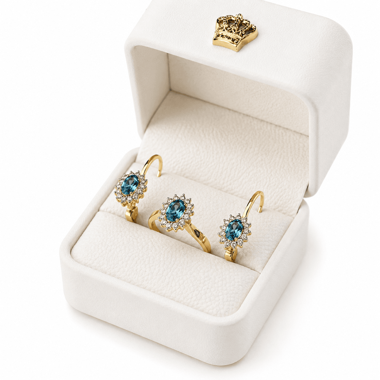 Gold ring and earrings with blue gemstones and diamond halos inside a white jewelry box.
